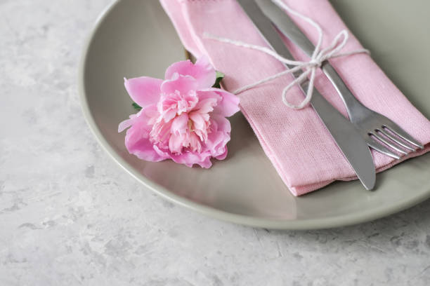 istock Close-up cutlery. Romantic table setting with pink peonies 1562939136