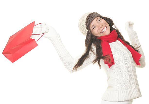 Christmas shopping xwoman with gift bag running joyful. Smiling young xwoman in winter clothes holding red shopping bags. Isolated on white background. Click for more: