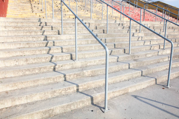 istock Metal staircase gray railing on concrete wall 1562958808