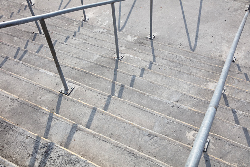 Metallic industrial designed stair step up to the higher floor, close-up and selective focus at foreground. Interior part and background photo.