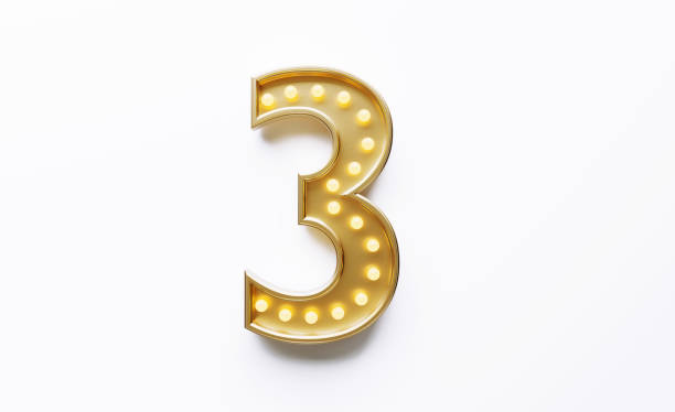 istock Gold Colored Number 3 Illuminated By Light Bulbs on White Background 1562965895