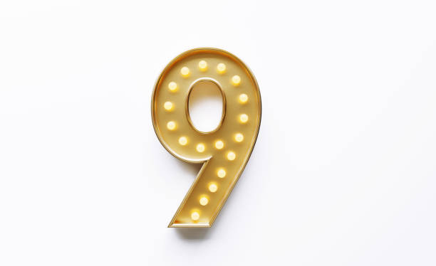 istock Gold Colored Number Nine Illuminated By Light Bulbs on White Background 1562967495