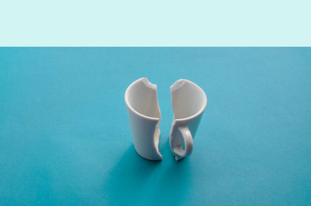 istock Damaged cup on a blue surface, revealing a moment of breakdown and desolation. 1562971375