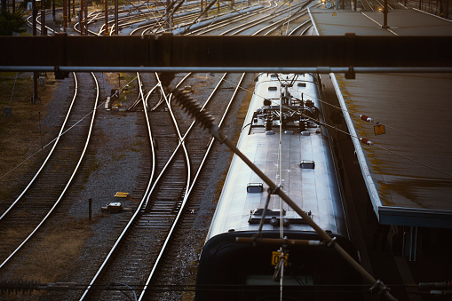 Train at station. View from above. Light reflecting on metal rooftop.