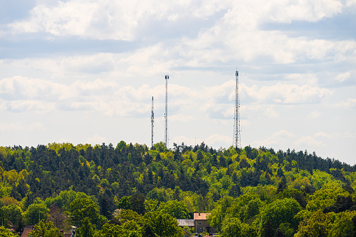 Tall communications masts towering above a forest.