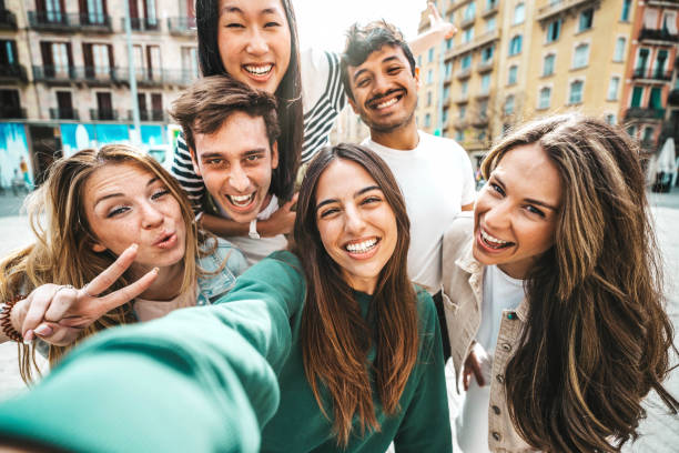 istock Happy multiracial friends taking selfie pic with smart mobile phone device outside - Group of young people laughing walking together on city street - Life style concept with guys and girls hanging out 1562976190