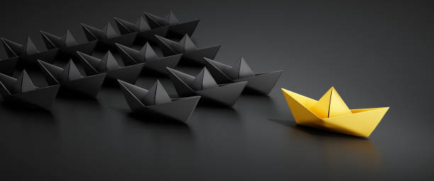 istock Black paper boats with golden leader 1562976449