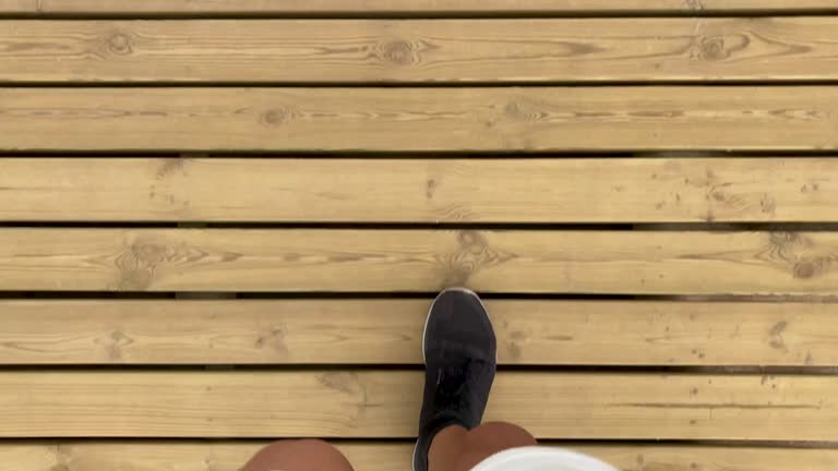 Man in shorts and sports shoes walking on wooden floor. Subjective camera. Walk. Wood. Step by Step. Exercise
