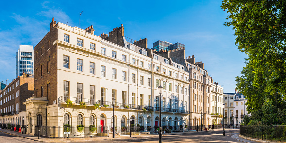 White stucco townhouses overlooking a leafy Georgian square in the heart of London, UK.