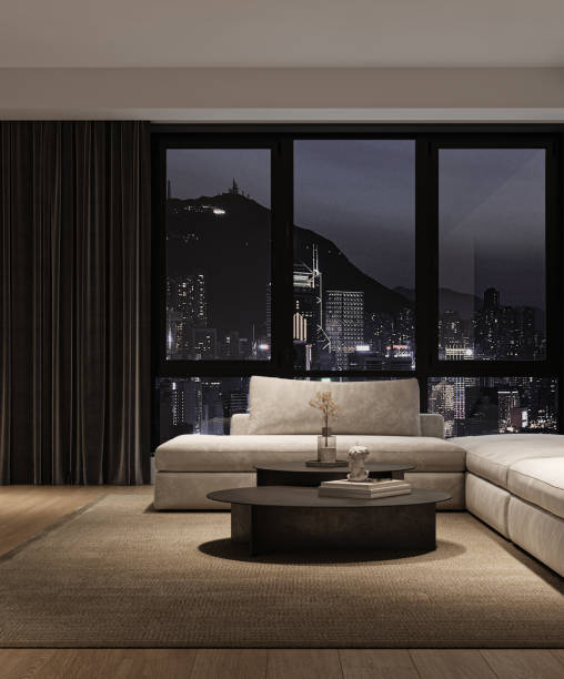 istock Modern luxury minimalist interior livingroom with large modular sofa, panoramic windows and city view with night lighting. 3d rendering. High quality 3d illustration 1562980564