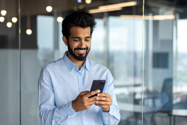 istock Young successful mature businessman inside the office using the phone, man holding a smartphone online application user, smiling browsing the internet and dialing a call 1562983240