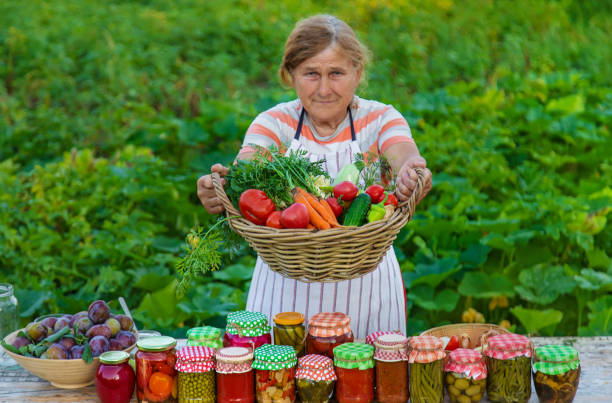 istock Senior woman preserving vegetables in jars. Selective focus. 1562988861