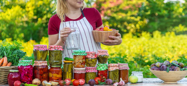 istock Woman with jar preserved vegetables for winter. Selective focus. 1562988873
