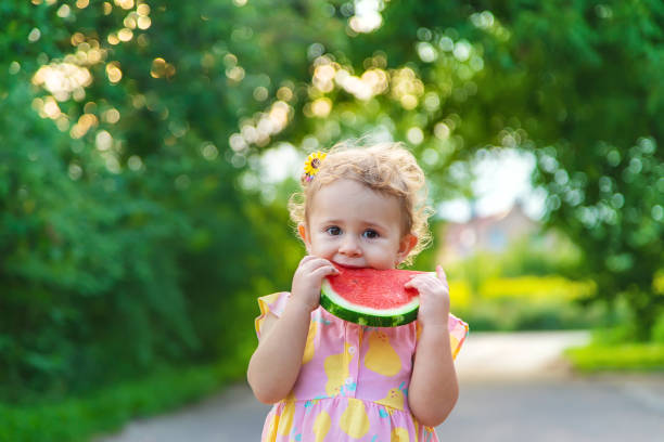 istock Child girl eats watermelon in summer. Selective focus. 1562988894