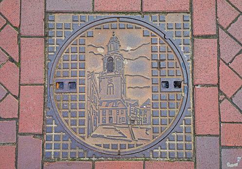 Decorated manhole cover in Winschoten, the Netherlands. D'Olle Witte is this tower called
