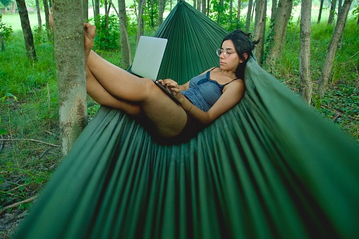 Girl on hammock working with portable pc