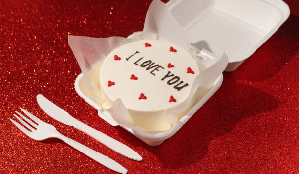 istock Small bento cake In box on the red shimmer background 1563018013