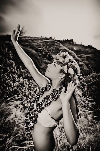 Young Hula Dancer posing for the camera wearing a lei and haku headpiece in black and white.