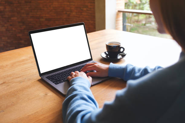 istock Mockup image of a woman using and typing on laptop computer with blank white desktop screen 1563032837
