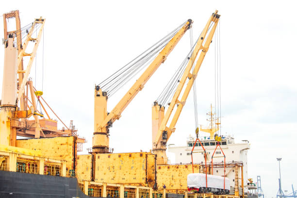 Unloading operation of project  cargo with port heavy lift cranes A crane on a large cargo ship docks loading a new diesel-electric locomotive.  at Laem Chabang Port