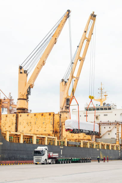 istock Unloading operation of project  cargo with port heavy lift cranes A crane on a large cargo ship docks loading Transport of Oversize Heavy cargo trailera  new diesel-electric locomotive.  at Laem Chabang Port 1563034879