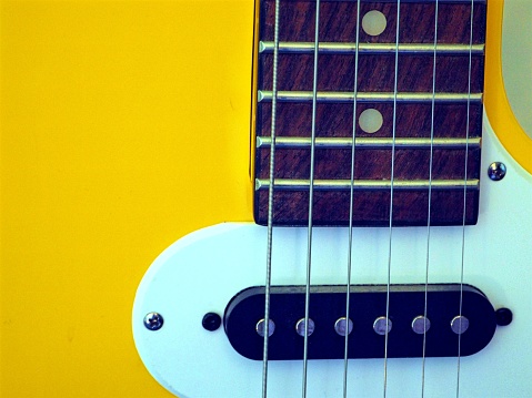 Closeup of a yellow string guitar