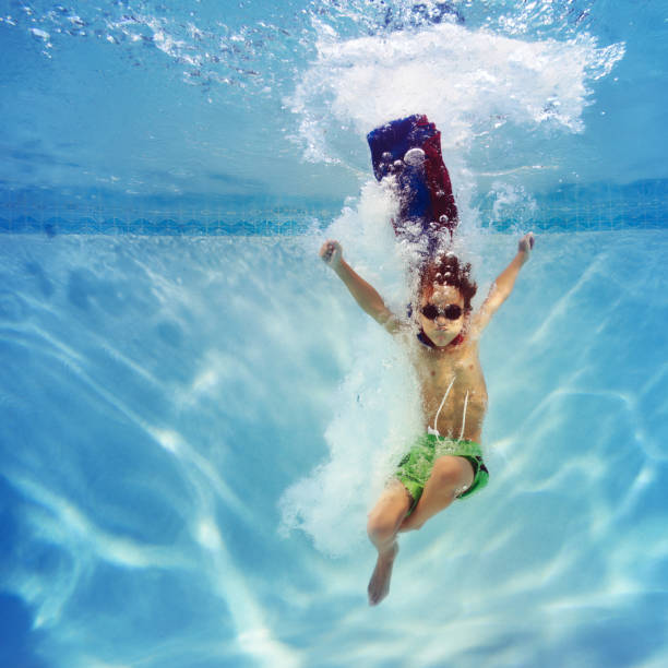 superhero boy diving into a swimming pool