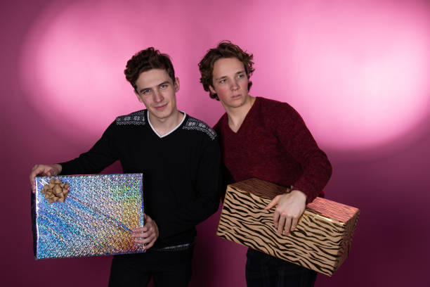 istock Two young attractive guys with gifts. 1563087602