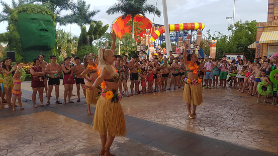 The tourists are watching the hula dance in Hawaii, USA.