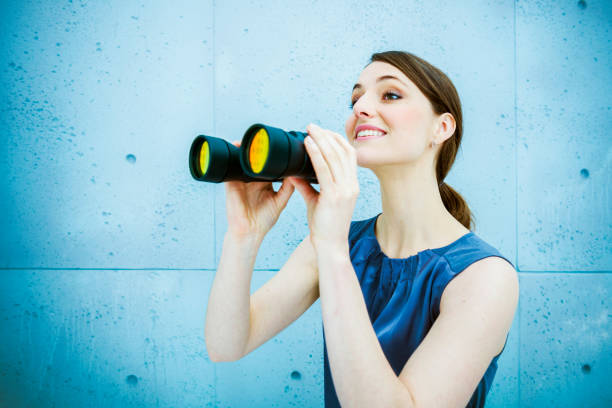 Businesswoman holding binoculars