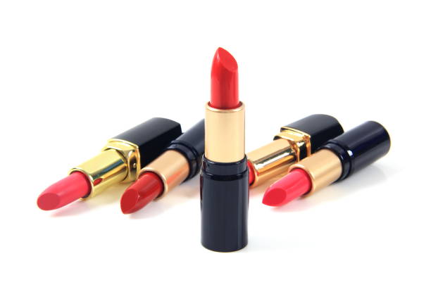 Three glossy lipsticks of different shade in a row, isolated on white background with a lot of copy space for text. Close up of a beauty product.