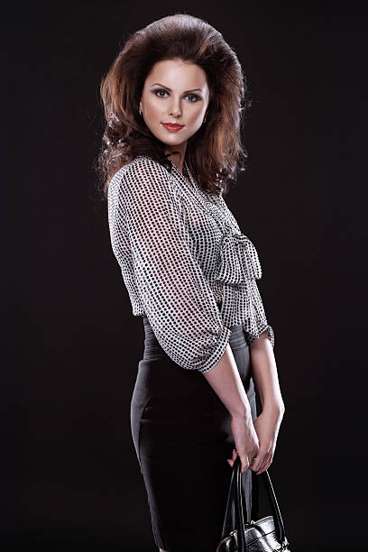 Studio shot of young beautiful woman on dark background. Professional make up and hair style.