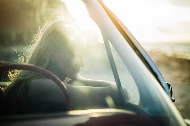 istock Woman sitting in car watching sunset 156313451