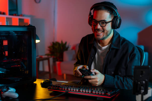 istock Happy young Asian man playing a video game 1563163790