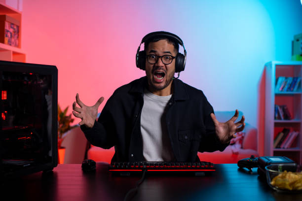 istock Angry young Asian man playing a video game feeling upset after loosing 1563163839