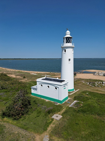 Aerial view and vertical shot of white lighthouse on a hot summer day. Location is at Keyhaven, Hampshire, UK.