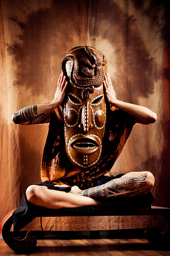 Woman holding big African mask