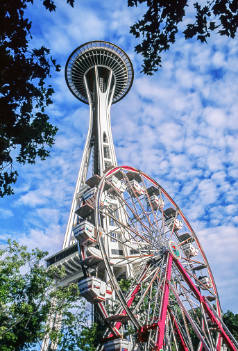 Space Needle and ferris wheel in public park in Seattle in 1997.The Space Needle is an observation tower located in Seattle, Washington, United States. The tower was built for the 1962 World's Fair and is considered the symbol of the city.