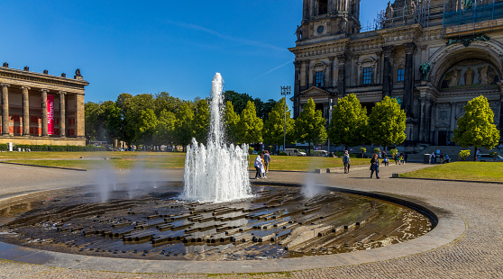 Berlin, Germany - May 30, 2023: Beautiful fountain with a rainbow in front of Altes (Old) Museum on Museum Island, Berlin, Germany