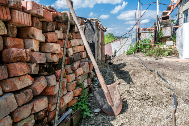 A stack of old bricks on the construction site of a cottage under construction. Repair of a village house