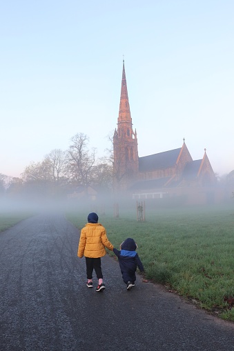 Sister and brother exploring nature in the early foggy morning.