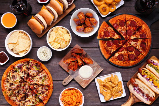 istock Junk food table scene, overhead view on dark wood 1563245272