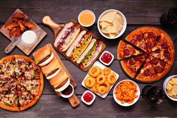 istock Junk food table scene, above view over dark wood 1563245273