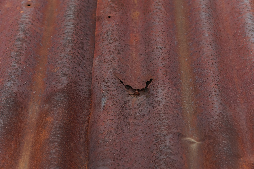 Old rusty tin roof. Metal rust. Corrosive rust on scrap metal. Can be used as an illustration for presentations.