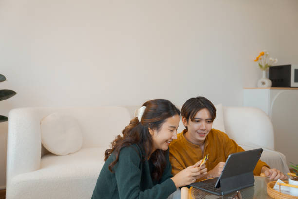 istock Couple online shopping on their digital tablet while relaxing at home. 1563269381