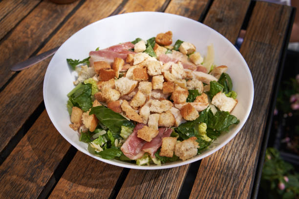 istock Caesar salad with croutons on a wooden table 1563311990