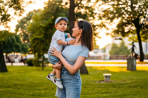 istock Young Mother Holding Her Son In The Park 1563322592