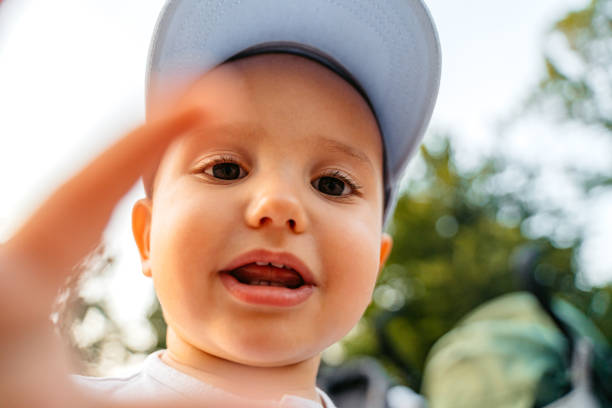 Close-up of a cute baby boy in the city park looking at camera.