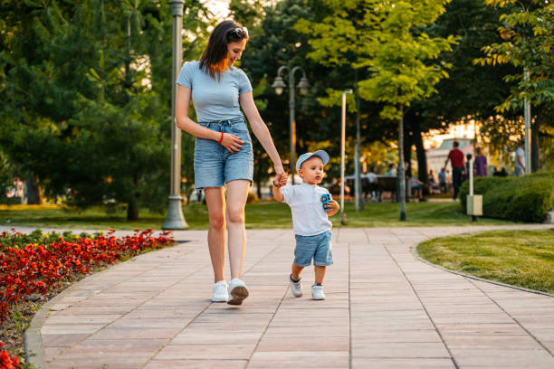 Young mother walking with her son in the park.
