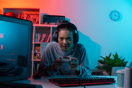 Young Asian woman concentrating on playing a video game